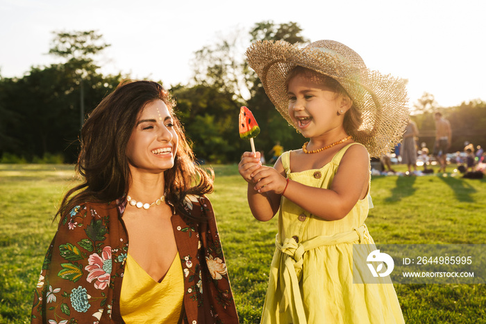 Mother having fun with her little daughter outdoors in nature green park.