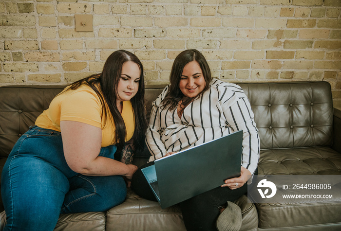 2 women look at laptop