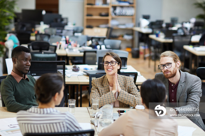 Portrait of cheerful businesswoman wearing glasses smiling happily during meeting in office, copy space