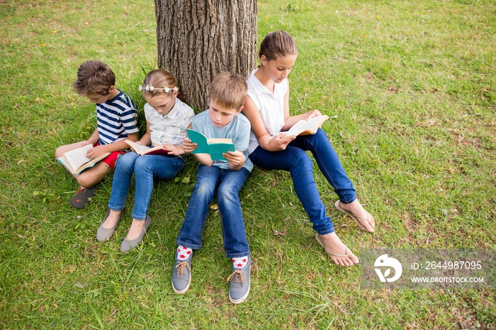 Kids reading book in park