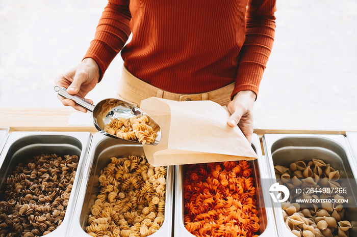 Woman is buying pasta in plastic free grocery store