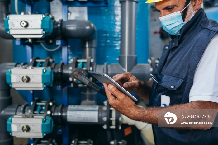 industry worker checking chemical water treatment equipment