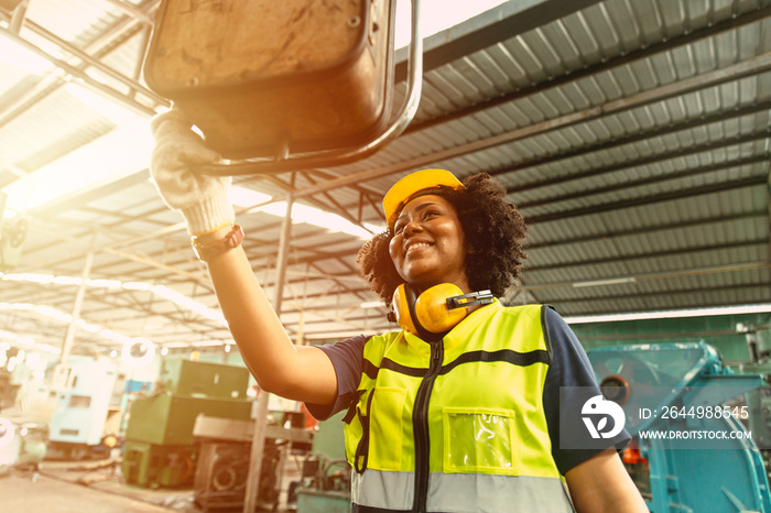 African American woman worker happy smiling working operate machine in heavy industry factory