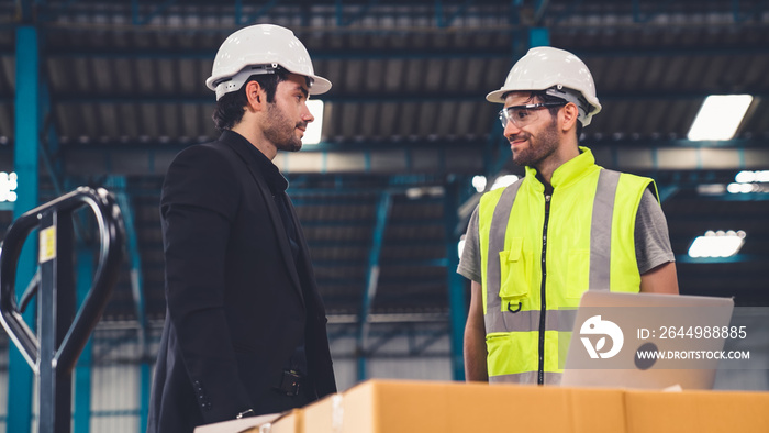 Two factory workers working and discussing manufacturing plan in the factory . Industry and engineering concept .