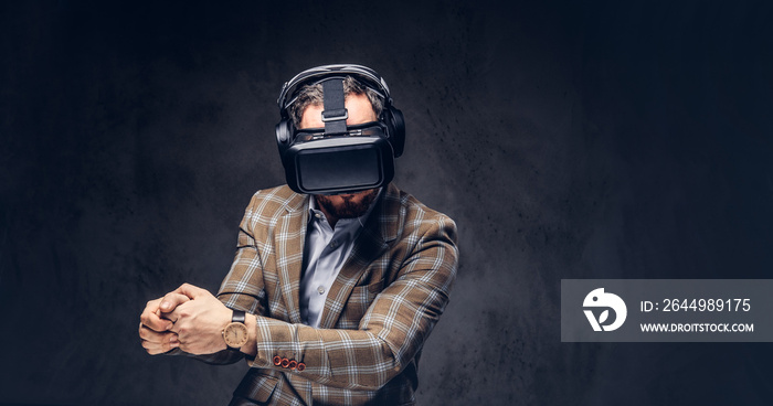 Studio portrait of a man wearing virtual reality glasses on a da