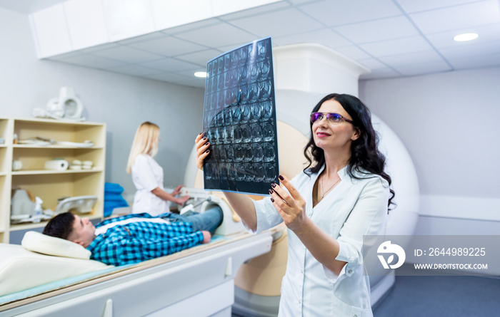 Radiologist with a male patient examining a mri scan