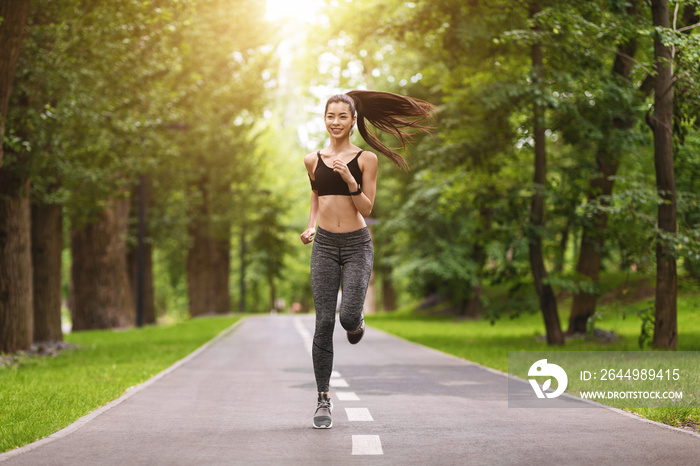 Sporty Morning. Cheerful Asian Girl Running On Path In City Park