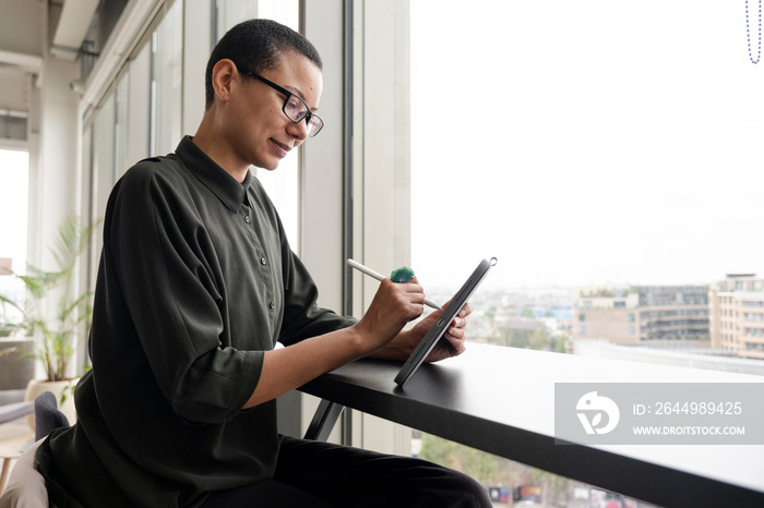 Woman using digital tablet in office