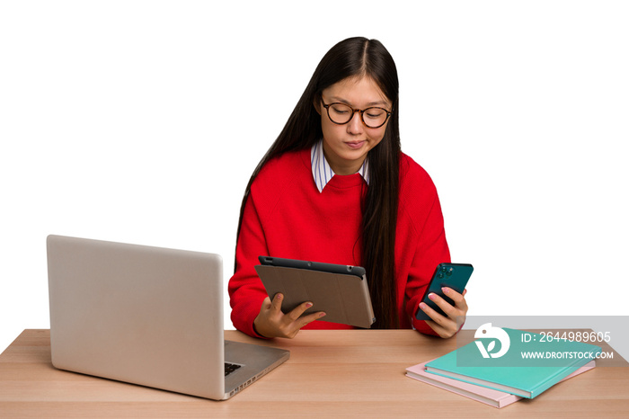 Young student asian woman in a workplace with a laptop isolated