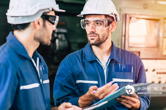 Engineer teamwork cooperate with worker to checking factory machine for safety and talking together.