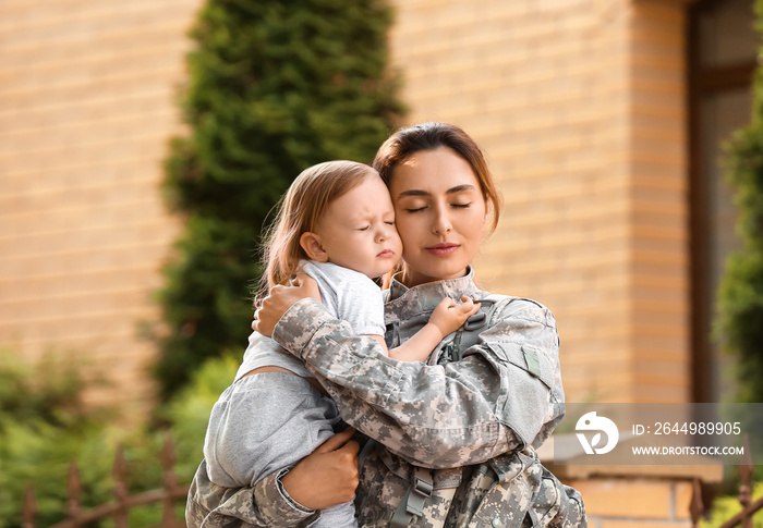 Female soldier with her little daughter outdoors