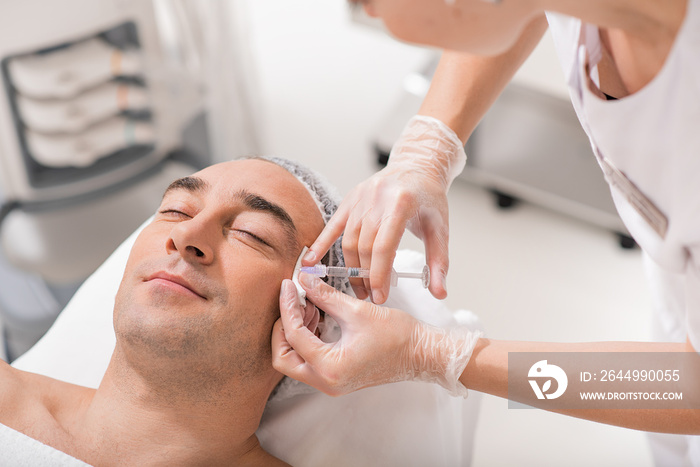 Calm male patient having plastic procedure