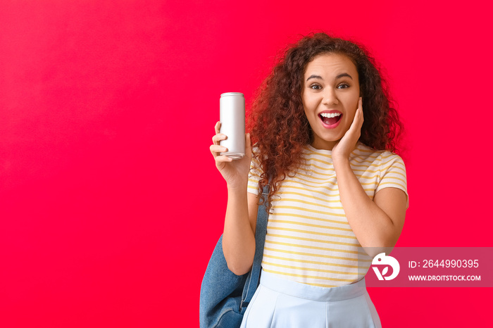 Surprised African-American woman with soda on color background