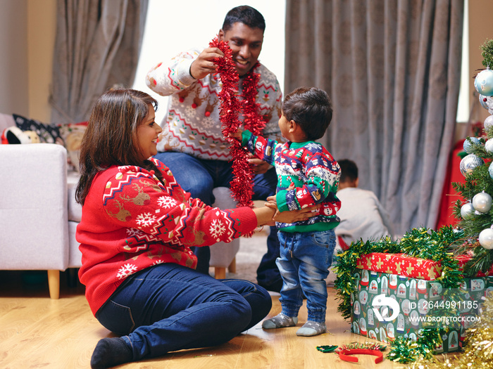 Parents and son playing with Christmas decorations