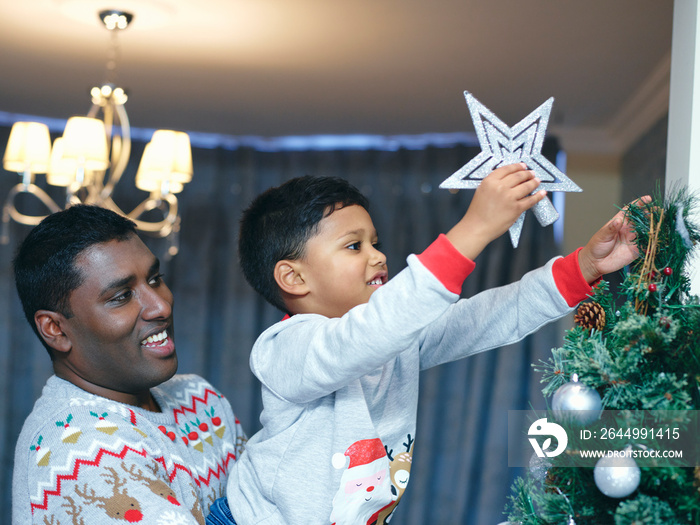 Father and son decorating Christmas tree