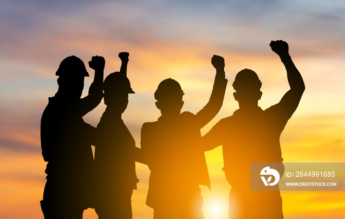 Silhouette of engineer and worker team with clipping path joining hands and celebration with sunset background, Success and Teamwork Concepts