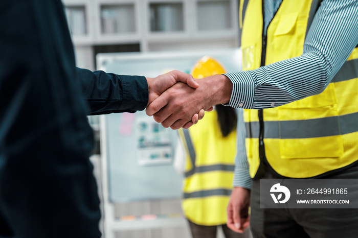 After concluding the meeting, competent investor shakes hands with engineer. Concept of the agreement between engineers and investors.