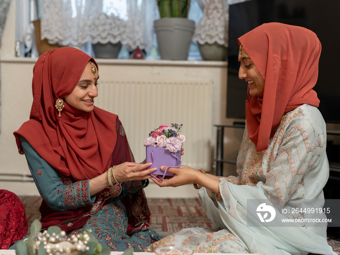 Women sharing gifts during Ramadan celebration at home