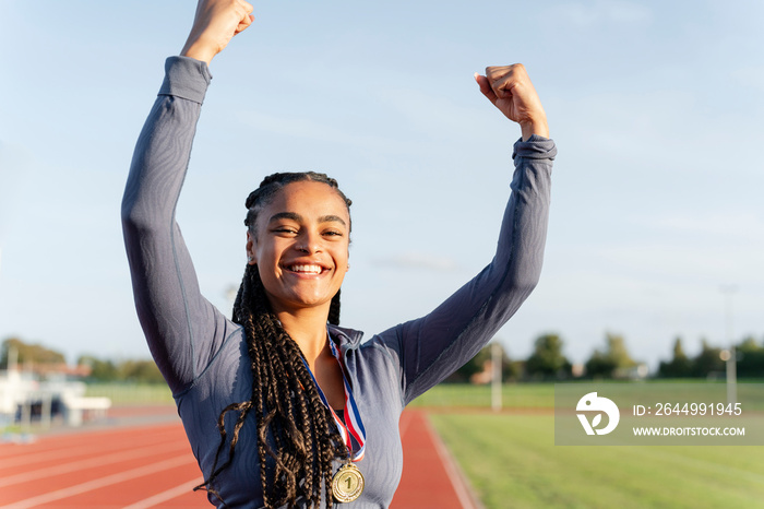 Portrait of female athlete celebrating with medal