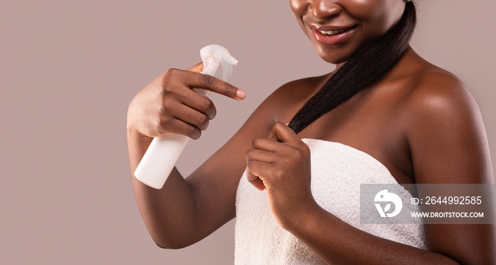 Split Ends. Young Black Lady Applying Hair Repair Treatment Spray After Bath