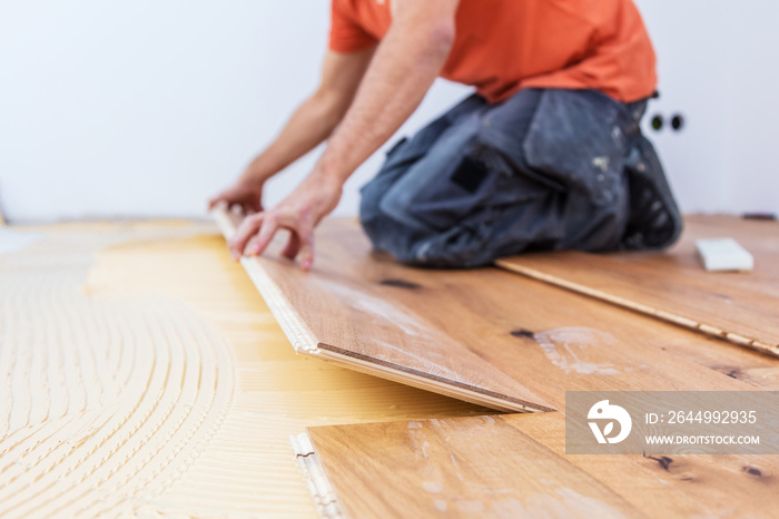 Handwerker verleget Parkett boden in einem modernen neubau Haus