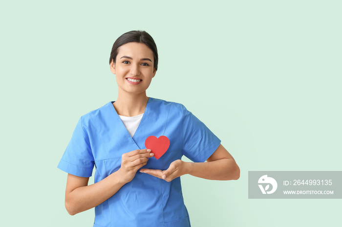 Cardiologist with red heart on color background