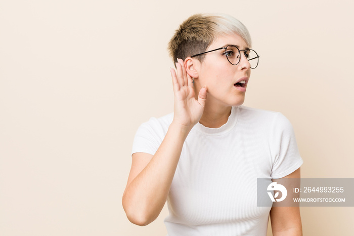 Young authentic natural woman wearing a white shirt trying to listening a gossip.