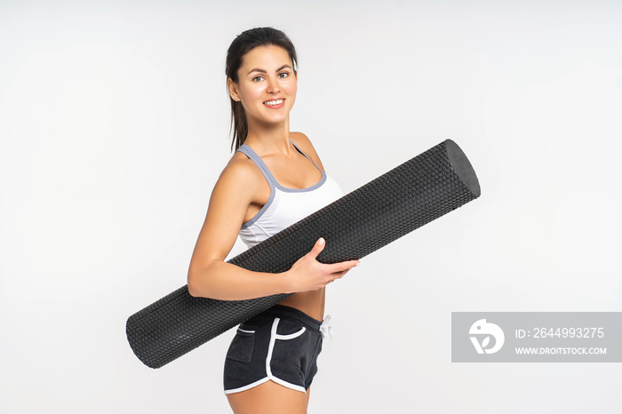 Athletic young woman is holding a foam roller for exercise