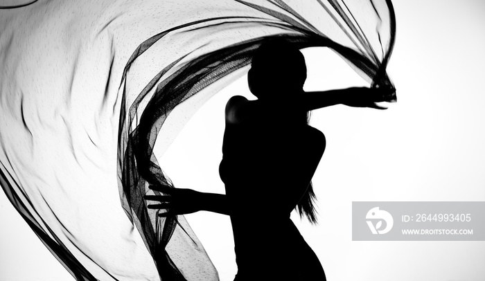 Silhouette of woman dancing with transparent fabric in black and white