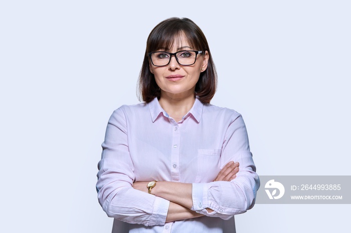 Portrait of confident middle-aged business woman on light background