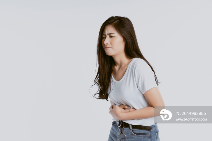 Asian woman unhappy looking sick, suffers from stomach ache stomachache isolated white background because of menstruation and eating spoiled food, Chronic gastritis. Abdomen bloating concept