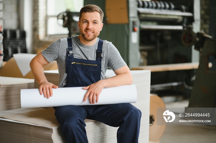 Man working in printing house with paper and paints