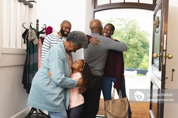 Image of happy multi generation african american family entering house and welcoming each other