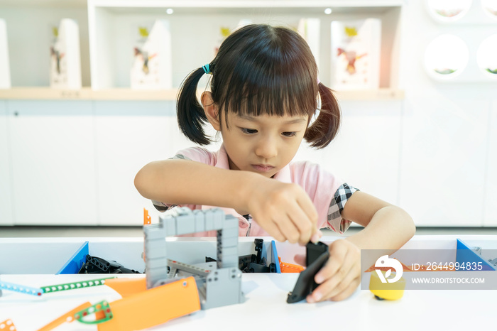 asian girl child having fun playing with colorful plastic blocks indoor at play school