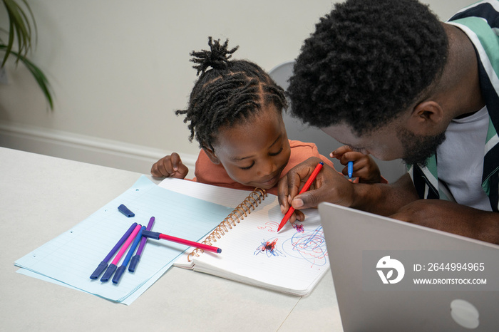 Father and daughter (2-3) drawing together in notepad