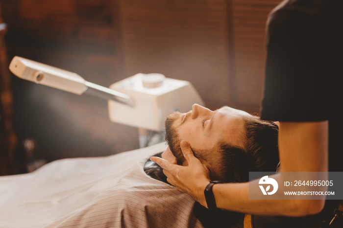 Vaporizer for face man in barbershop. Beard softening steam in preparation for shaving razor, vintage color