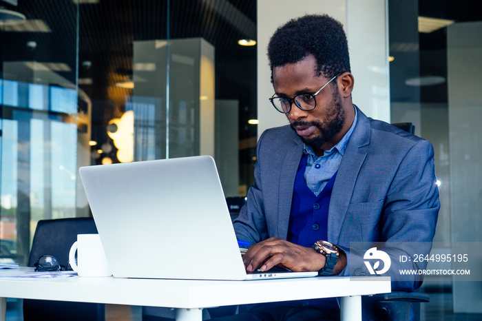 Handsome cheerful african american in a modern office with a panoramic window