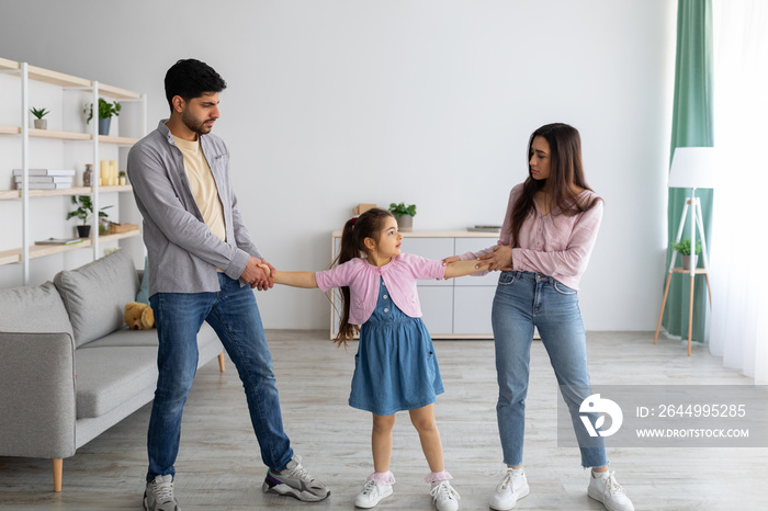 Divorce concept. Arab parents fighting over their child, mad man and woman quarrelling, standing in living room