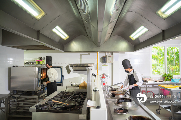 Asian two chefs prepare meals in the restaurant’s kitchen. Modern kitchen.