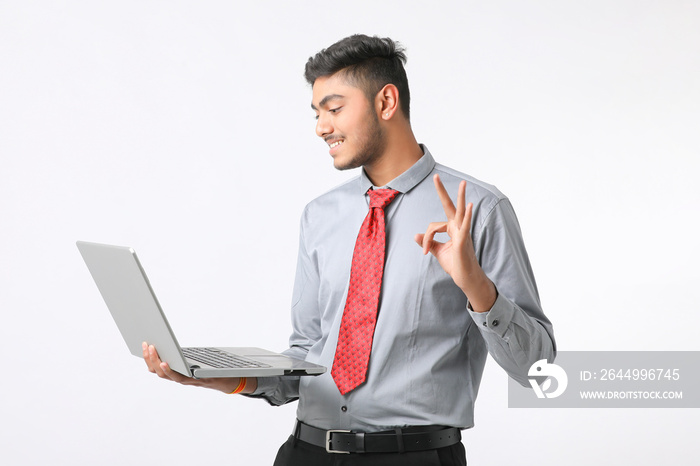 Young indian man using laptop on white background.