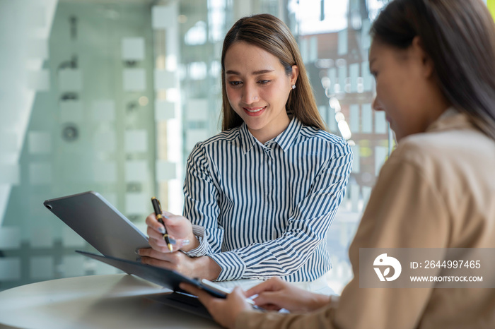 Negotiation, Analysis, Discussion, Asian woman economist and marketer pointing to a financial data sheet to plan investments to prevent risks and losses for the company