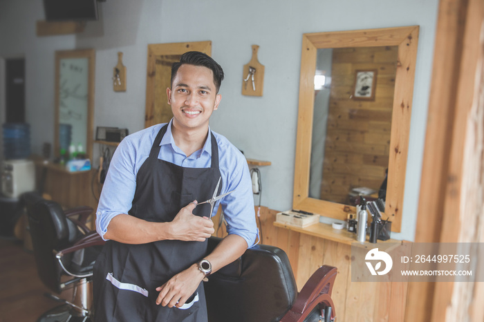 young male barbershop owner smiling