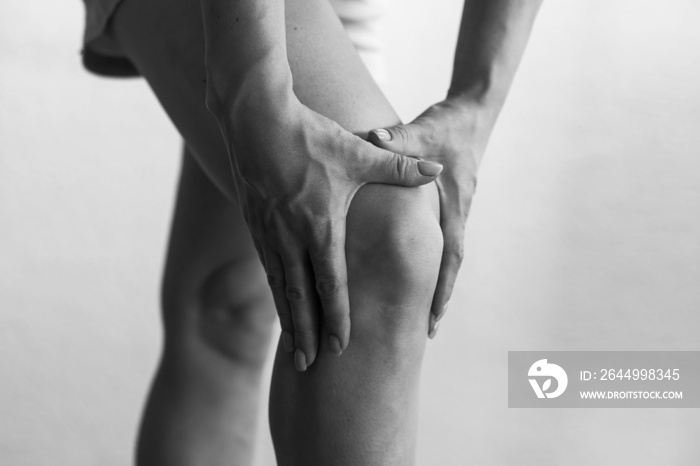 Closeup woman hand hold knee with pain symptom, health care and medical concept