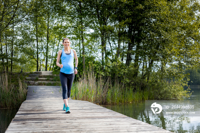 Active pregnant woman running outdoor, sport during pregnancy