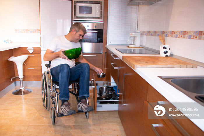 A man in a wheelchair preparing food in the kitchen