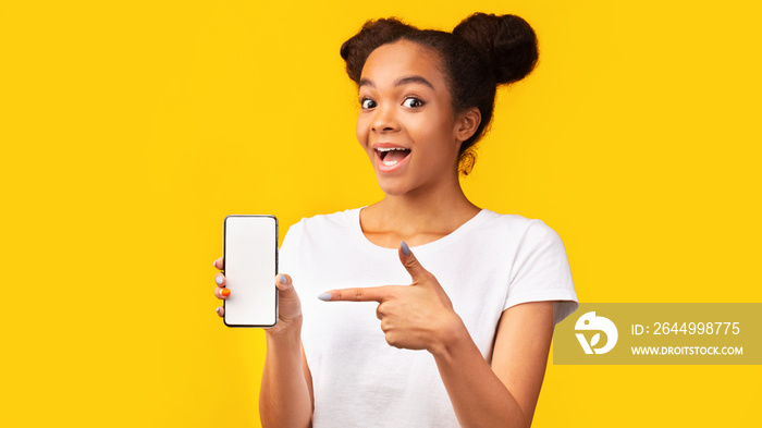 Amazed black girl pointing at blank white mobile screen