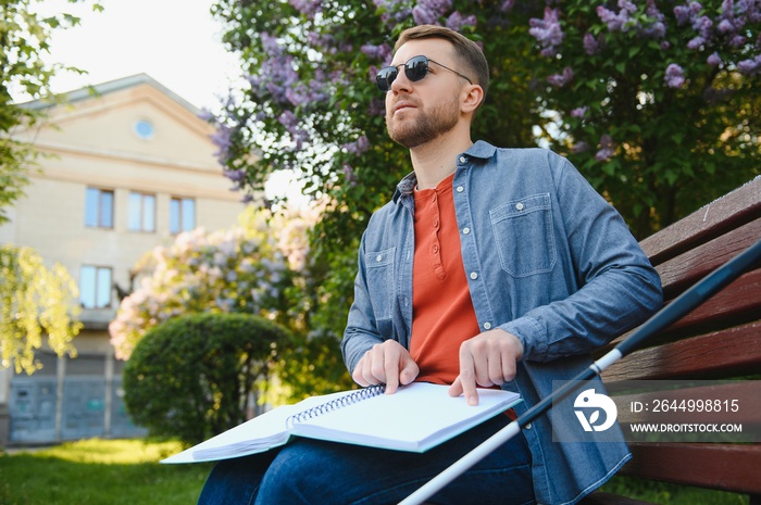 Blinded man reading by touching braille book