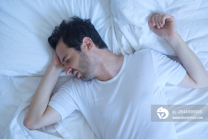 Thoughtful man cannot sleep because of insomnia