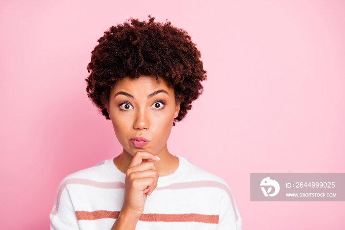 Photo of amazed misunderstanding cute funny black woman touching her chin lost deeply in thoughts wearing white striped sweated isolated over pink pastel color background