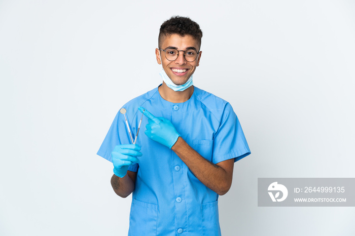 Brazilian dentist holding tool isolated on white background pointing to the side to present a product